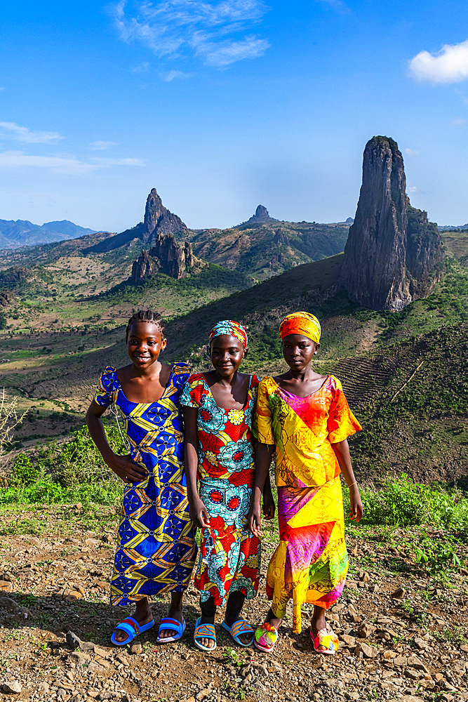 Three Kapsiki tribal girls in front of the lunar landscape of Rhumsiki , Rhumsiki, Mandara mountains, Far North province, Cameroon, Africa