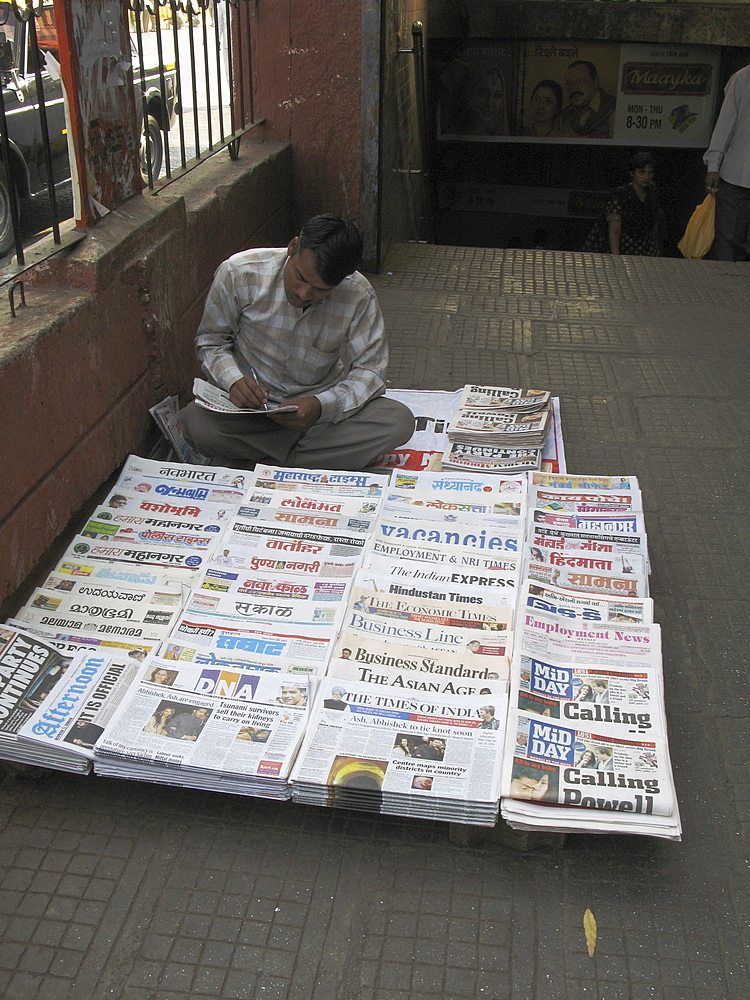 India. Newspaper vendor at a train station, mumbai. Photo julio etchart