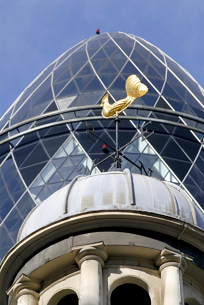 Uk old dome with the tower of the swiss re modern building in the background in the city of london