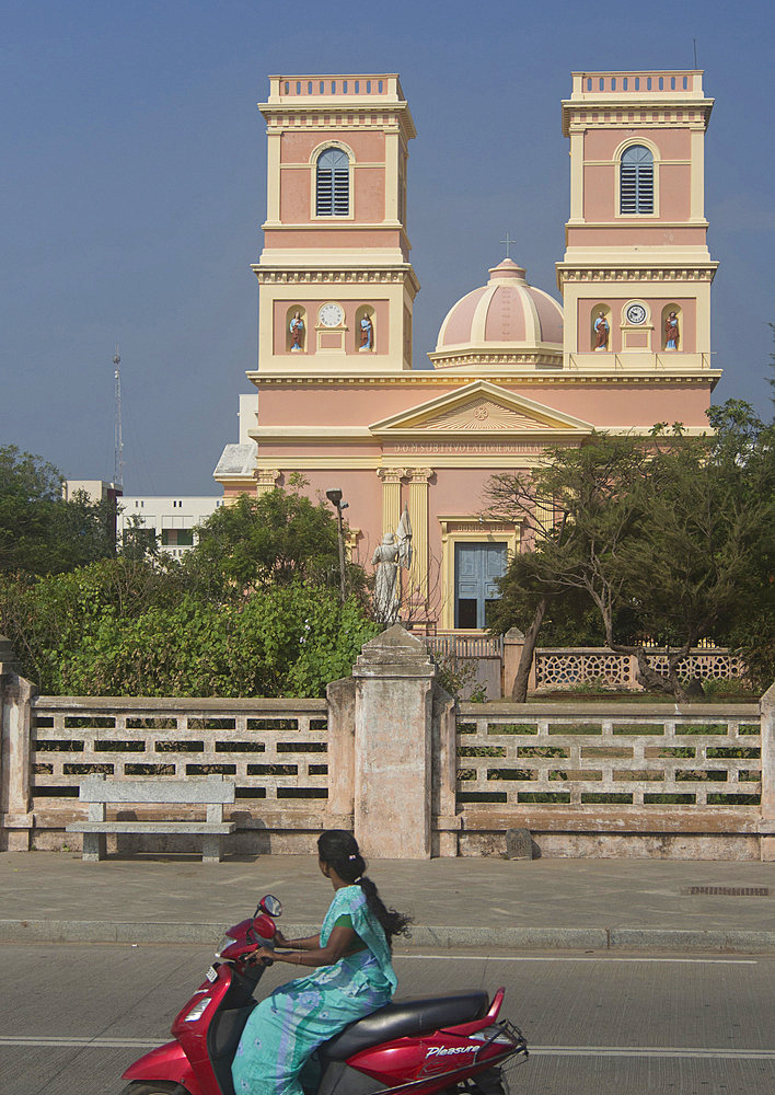 Local woman drives motorbike past traditional French architecture in the union territory of Pondicherry, Tamil Nadu, India, Asia