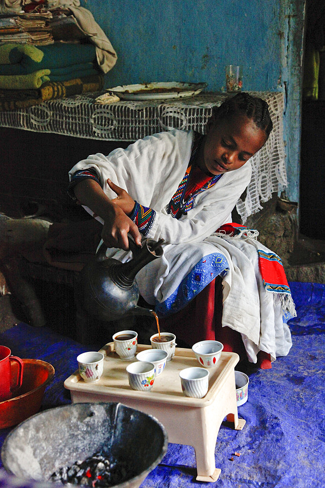 Young woman performing a traditional coffee ceremony in a village in Ethiopia, Africa