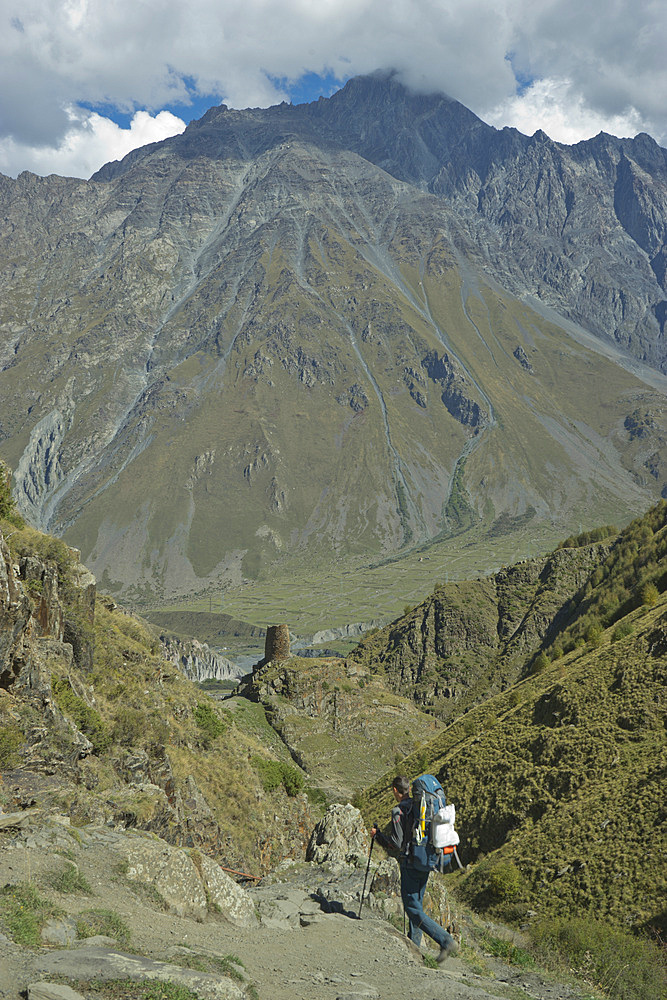 Tourists trekking near the Gergeti Holy Trinity Church by the river Chkheri, under Mount Kazbegi at an elevation of 2170 meters in the Caucasus, Georgia, Central Asia, Asia