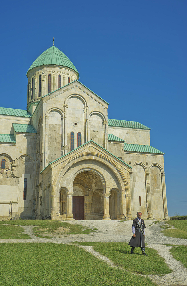 Priest walking by exterior of Bagrati Christian Orthodox Cathedral, UNESCO World Heritage Site, Kutaisi, Georgia, Central Asia, Asia