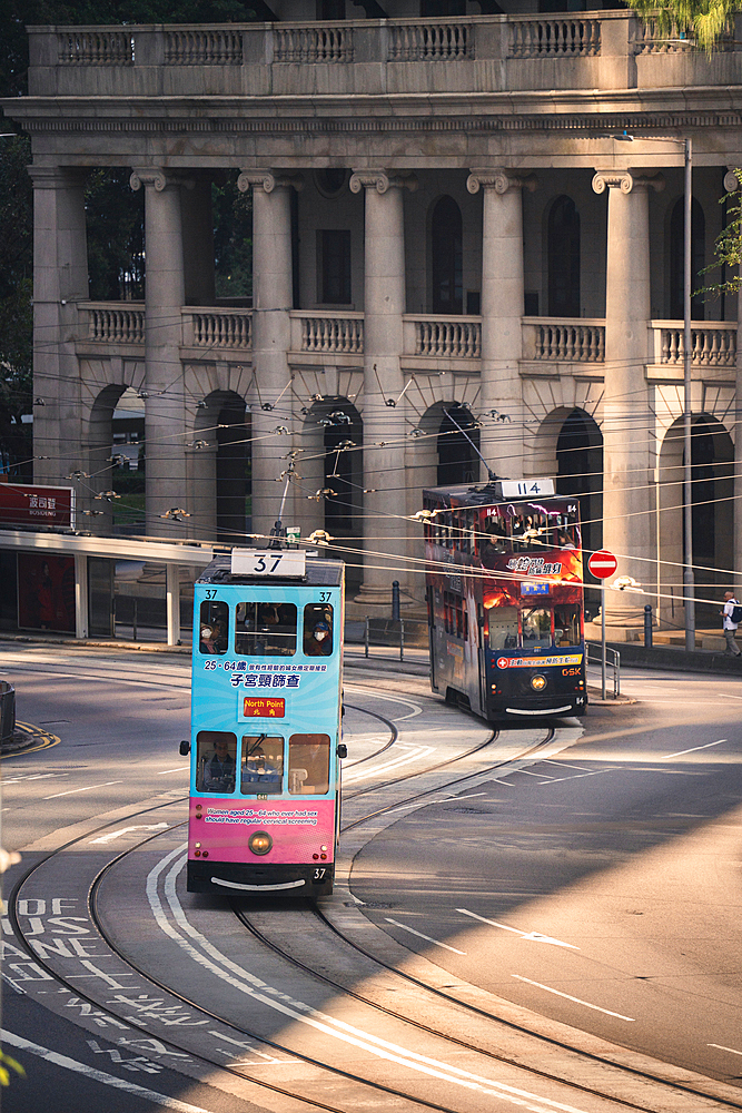 An vertical action shot of a Hong Kong Tram going past the colonial Building Old Supreme Court