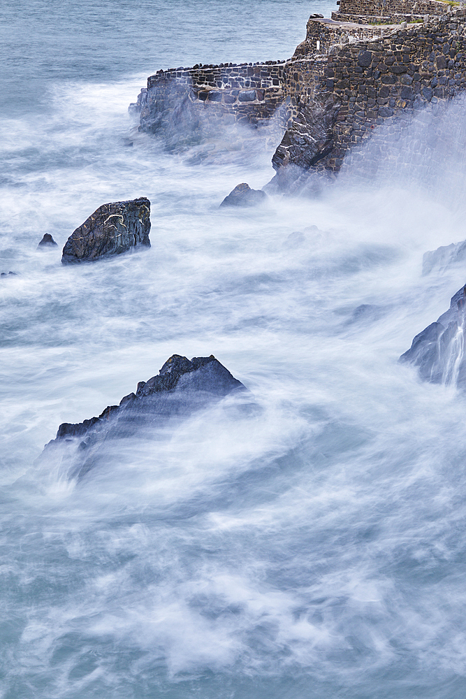 On a rising tide, evening surf pounds the historic harbour wall at Hartland Quay, on the Atlantic coast of Devon, England, United Kingdom, Europe