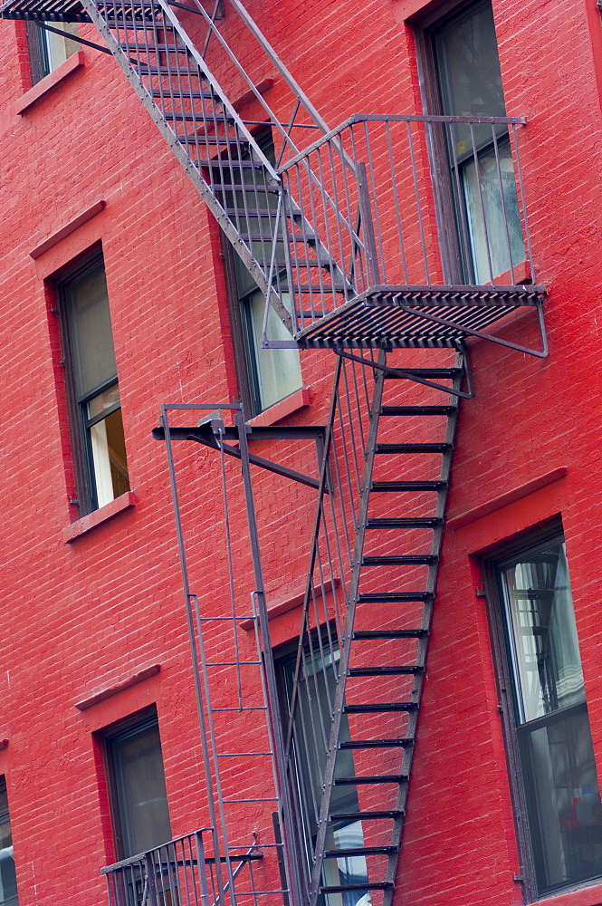 Red painted tenement block and fire escapes, New York, United States of America, North America