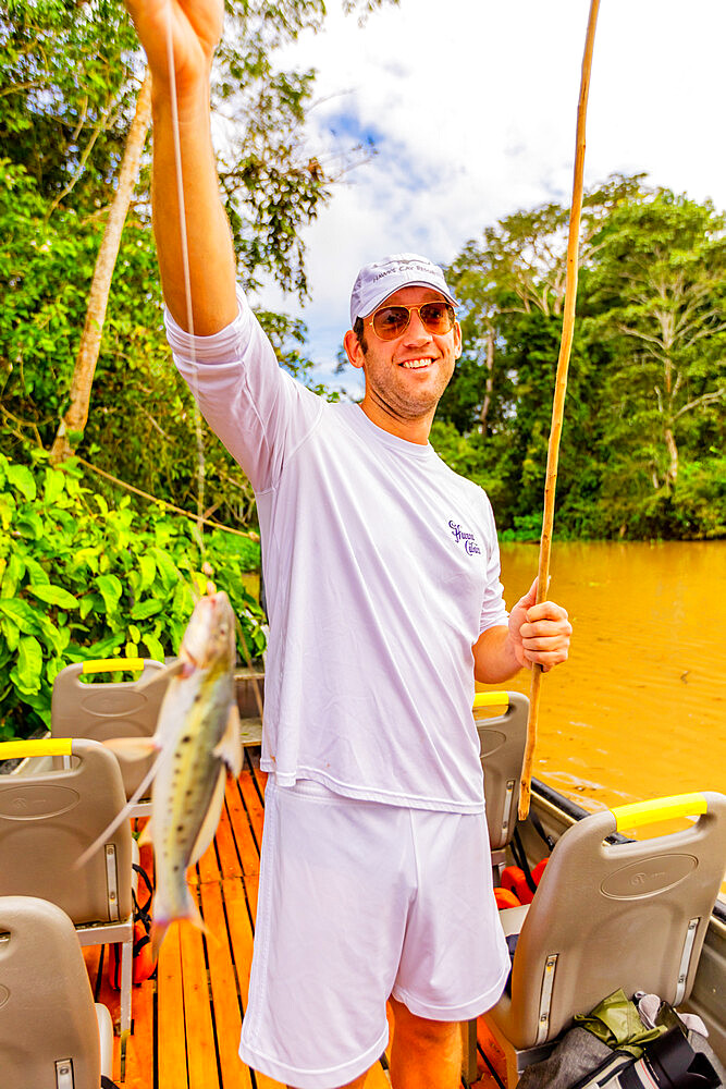 Man showing his freshly caught fish from the Amazon River, Peru, South America