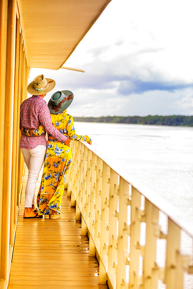 Couple enjoying the view of the Amazon River aboard a river boat, Peru, South America