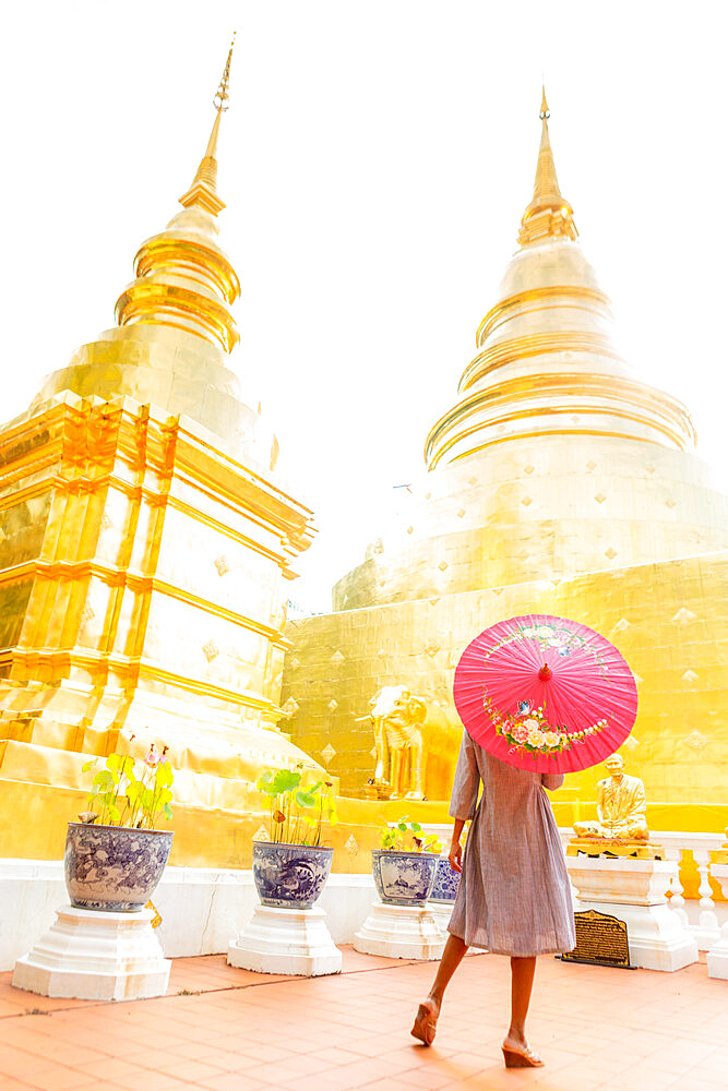 Woman with red umbrella at Wat Phra Singh Woramahawihan, Chiang Mai, Thailand, Southeast Asia, Asia