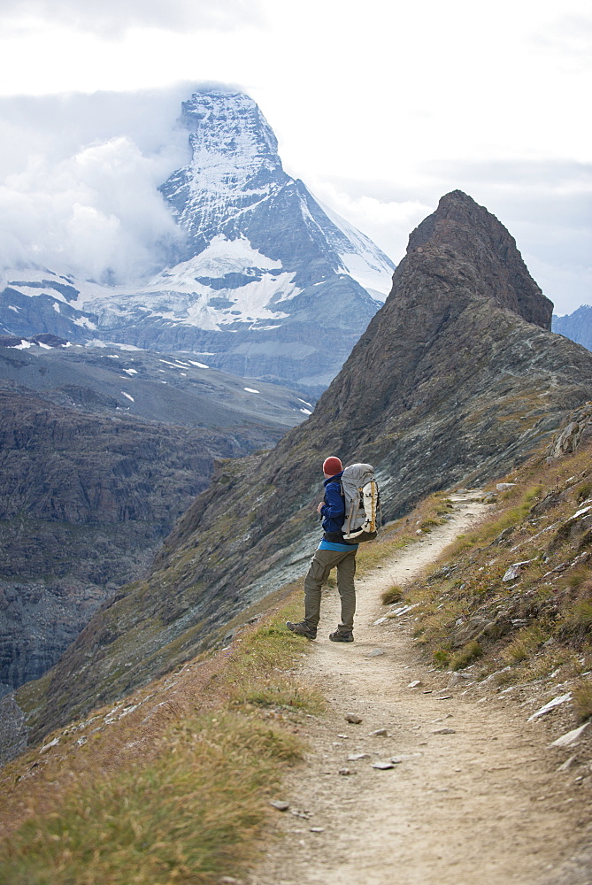 Hiking a trail in the Swiss Alps near Zermatt with a view of The Matterhorn in the distance, Zermatt, Valais, Switzerland, Europe