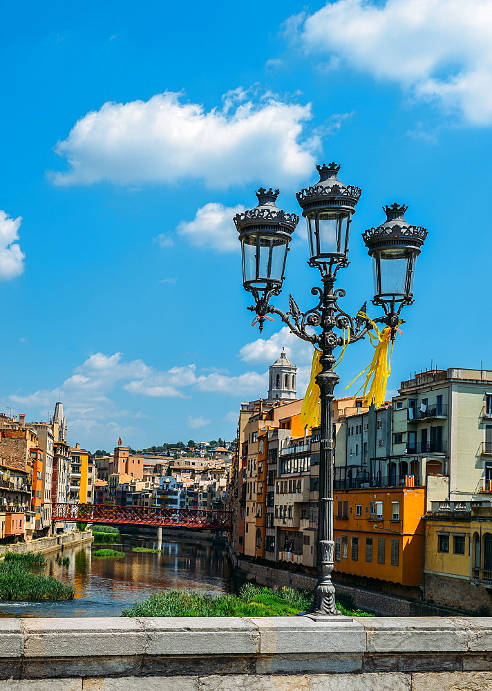 Colourful houses on the embankment of the River Onyard in historic centre and Eiffel Bridge in far background, Girona, Catalonia, Spain, Europe