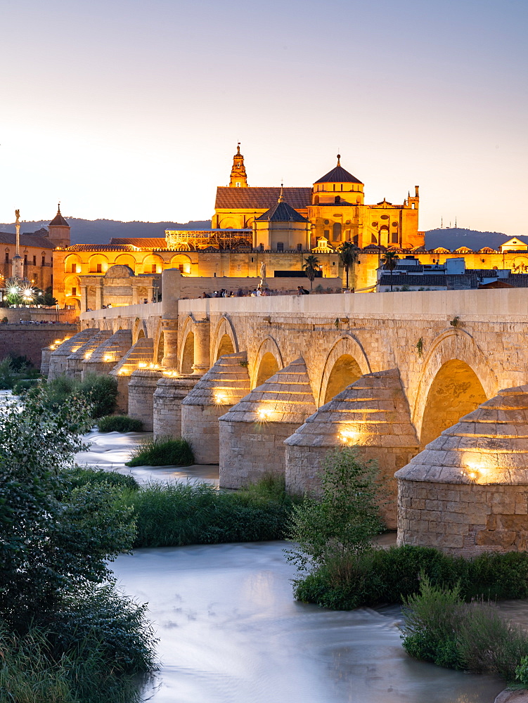 The Roman Bridge (Puente Romano) and The Great Mosque of Cordoba lit up during evening sunset, UNESCO World Heritage Site, Cordoba, Andalusia, Spain, Europe