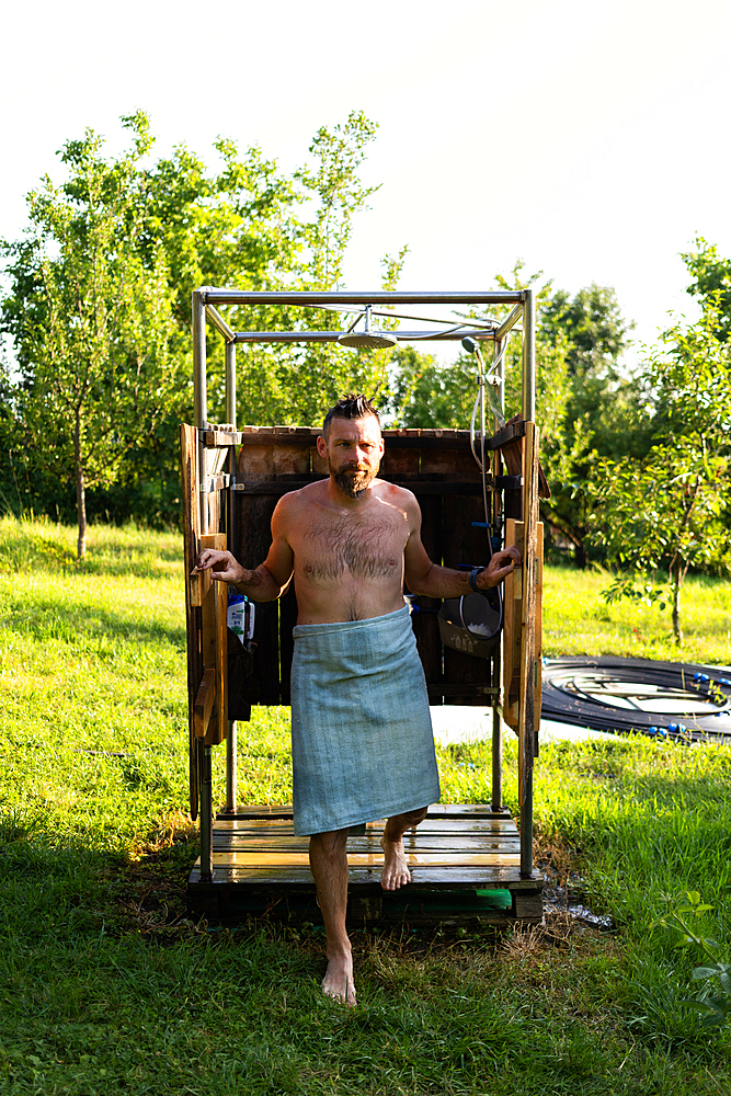 man taking a shower in the garden