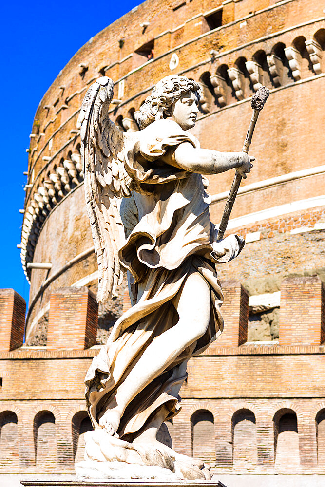 An angel statue from Ponte Sant'Angelo with Castle of the Holy Angel (Castel Sant'Angelo), Rome, Lazio, Italy, Europe