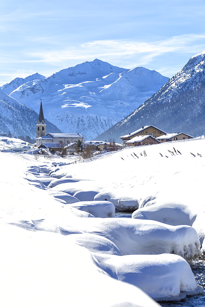 Torrent with church in winter snow, Livigno, Valtellina, Lombardy, Italy, Europe