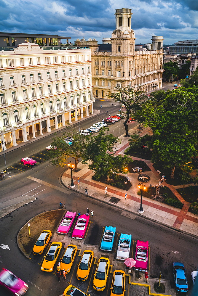 Aerial view colourful old American taxi cars parked in Havana at dusk, La Habana, Cuba, West Indies, Caribbean, Central America