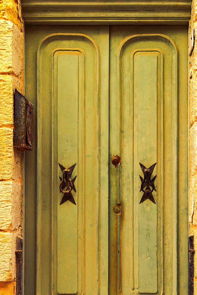 Traditional brass door knockers with Maltese cross design outside a building in the alleys of the old city of Birgu (Citta Vittoriosa), Malta, Mediterranean, Europe