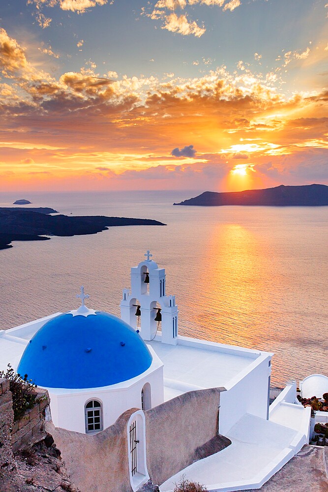 A white church with blue dome overlooking the Aegean Sea at sunset, Santorini, Cyclades, Greek Islands, Greece, Europe