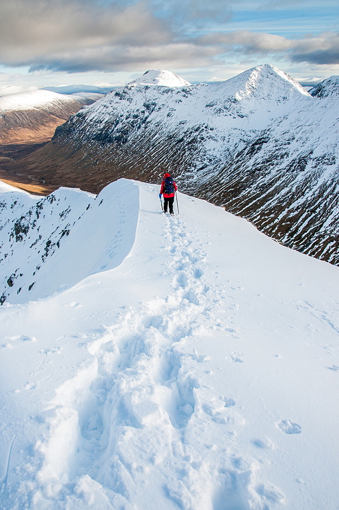 A female walker descending from the summit of Stob Dubh on Buchaille Etive Beag on a crisp winter day, Highlands, Scotland, United Kingdom, Europe