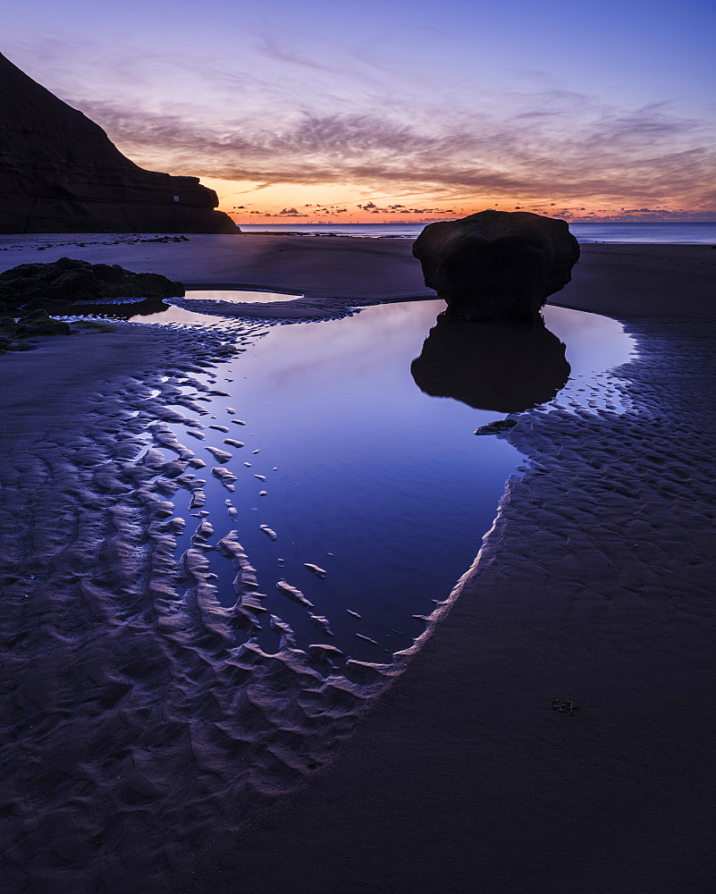 Dawn twilight with clouds reflected in a pool on the beach at Orcombe Point, Exmouth, Devon, England, United Kingdom, Europe