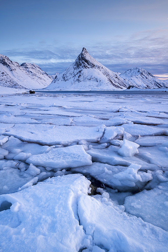 Snow covered steep mountain with ice formations in winter scene on Lofoten Islands, Arctic, Norway, Europe