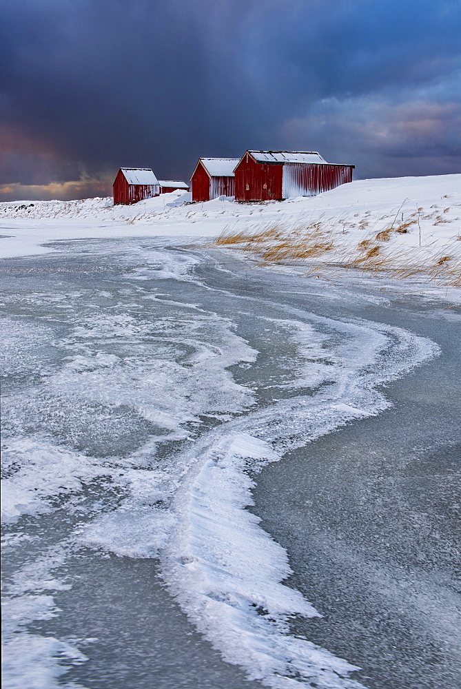 Typical fishermen houses Ice formations with dramatic sky in winter, Eggum, Lofoten Islands, Arctic, Norway, Europe