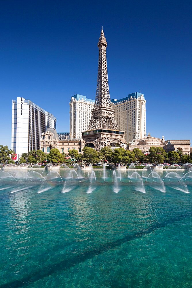 View across lake to replica Eiffel Tower at the Paris Hotel and Casino, Bellagio fountains in foreground, Las Vegas, Nevada, United States of America, North America