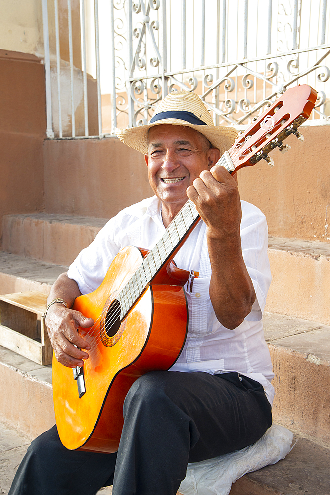 Local man singing and playing his guitar in the Plaza Mayor of Trinidad, Cuba, West Indies, Caribbean, Central America