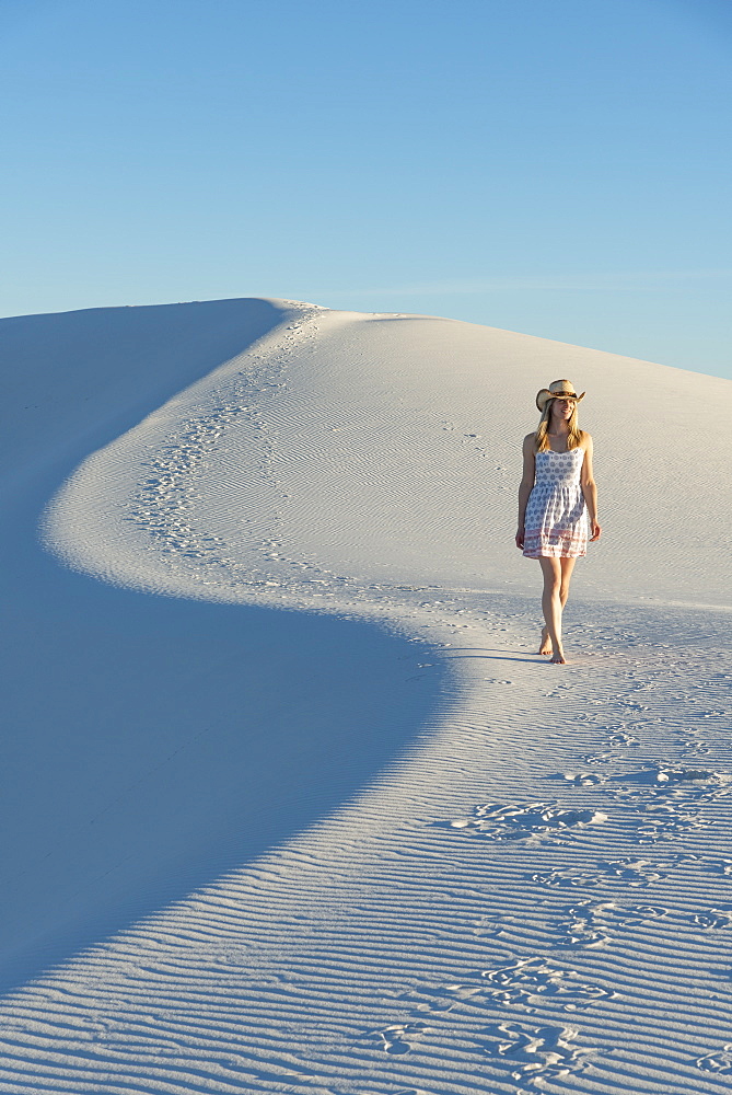 A woman walking along the S curve of a dune's ridge in White Sands National Park, New Mexico, United States of America, North America