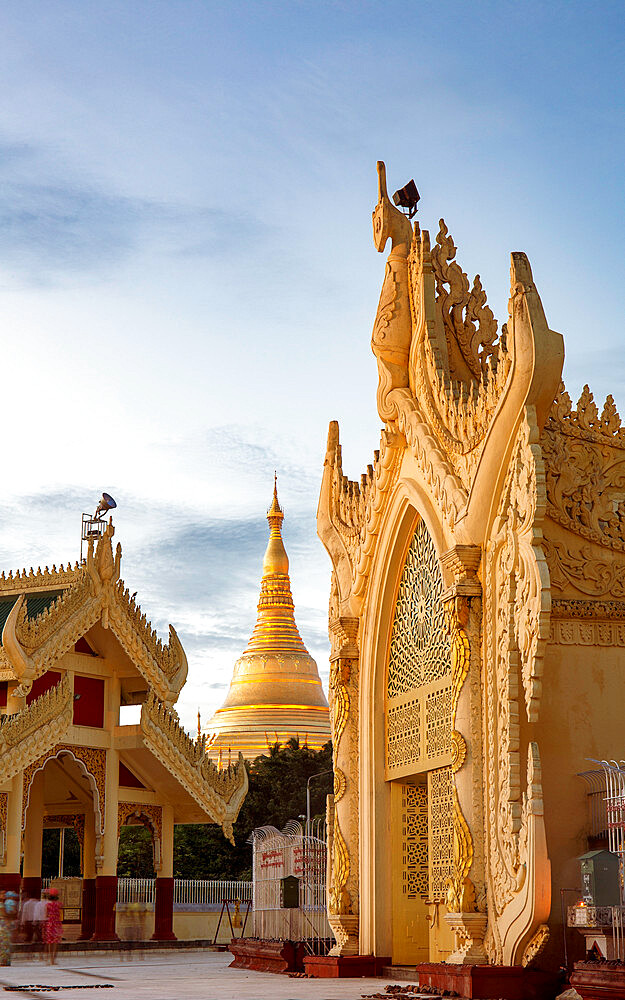 Maha Wizaya Pagoda at dusk, with the shining gold chedi (Stupa) of Shwedagon pagoda in the centre background, Yangon (Rangoon), Myanmar (Burma), Asia