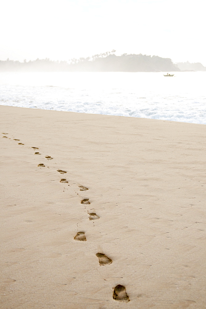 Footprints in the sand at sunrise on Talalla Beach, Sri Lanka, Asia