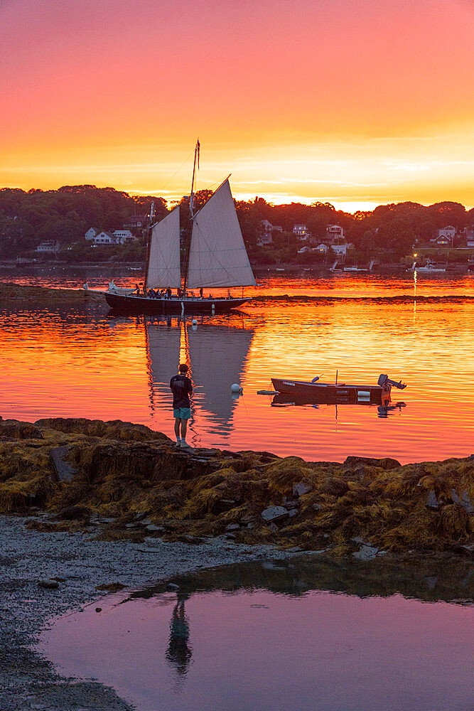 A schooner returns to dock at sunset at Bailey Island, Casco Bay, Maine, United States of America, North America