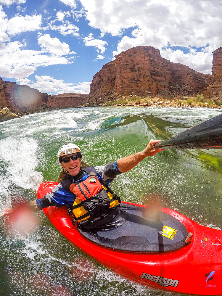 Skip Brown surfs his whitewater kayak on a glassy standing wave on the Colorado River through the Grand Canyon, Arizona, United States of America, North America