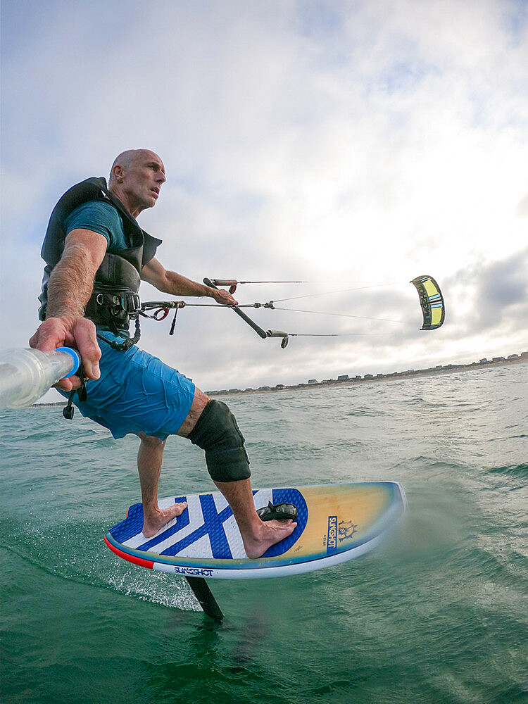 Photographer Skip Brown on his foiling kiteboard in the Atlantic Ocean off Nags Head, North Carolina, United States of America, North America