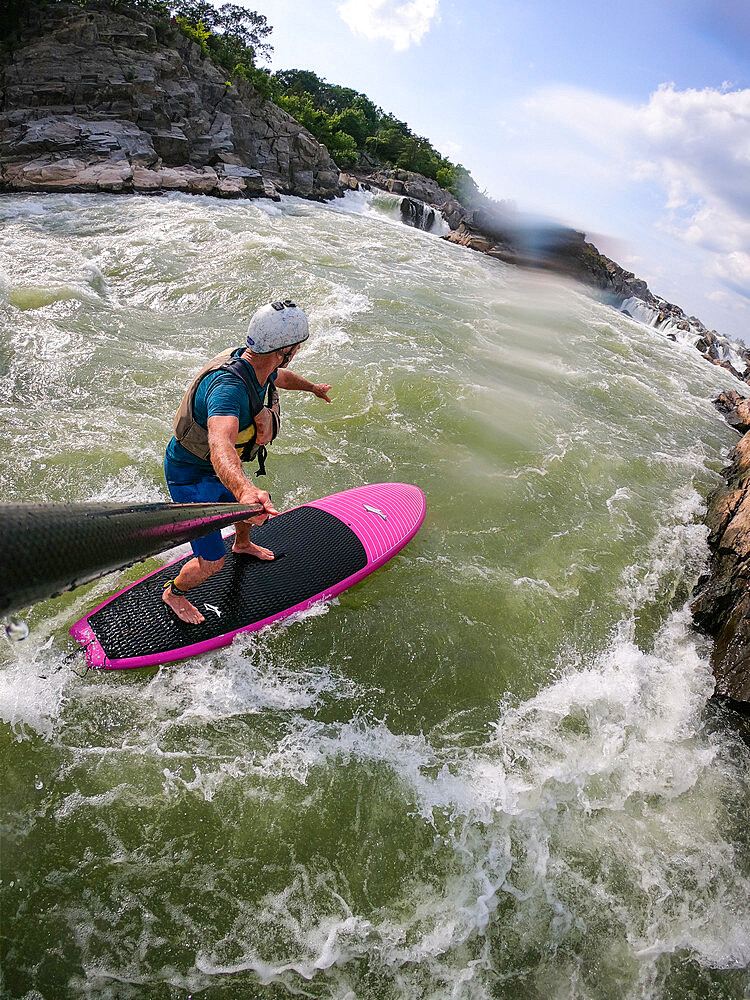 Photographer Skip Brown stand up paddle surfs challenging whitewater below Great Falls of the Potomac River, border of Maryland and Virginia, United States of America, North America