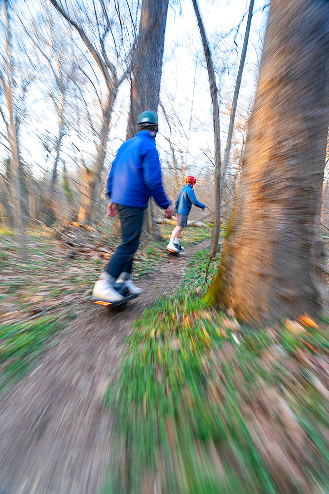 Brothers ride their One-Wheels on a single track mountain biking trail next to the Potomac River. Bethesda, Maryland, United States of America, North America