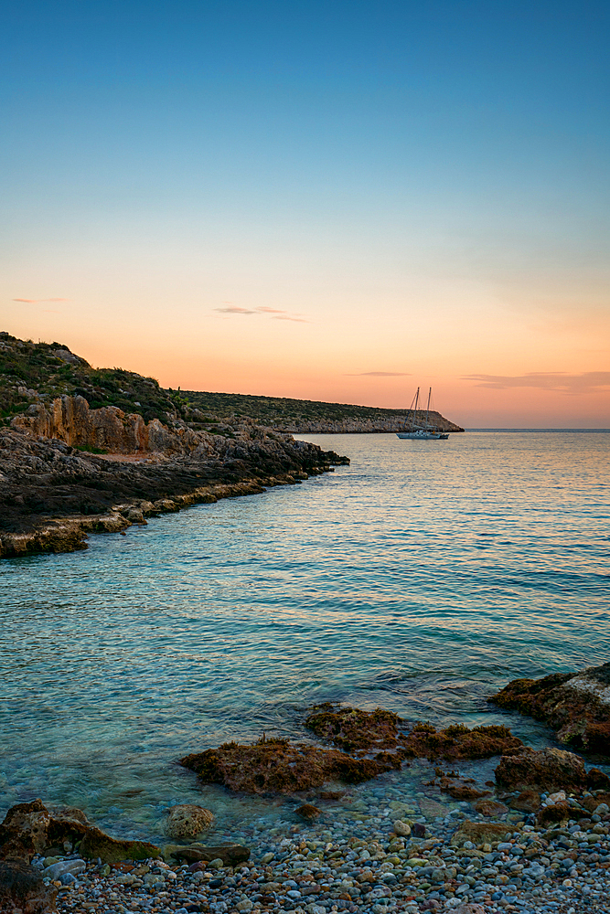 Boat on a beach bay at Cape Tainaron Matapan at sunset, in Greece