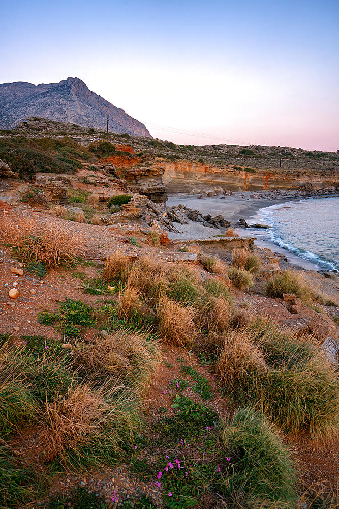 Aspes beach natural holes on the rocks full with water at sunset with turquoise water sea of Greece on the background