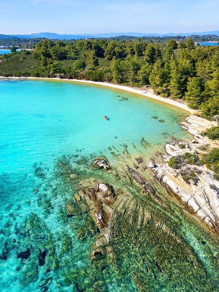 Diaporos island with wild beaches and a kayak on the turquoise water drone aerial view in Greece