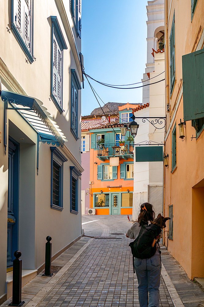 Woman with dog in a backpack walking in Nafplion historic city center in Greece