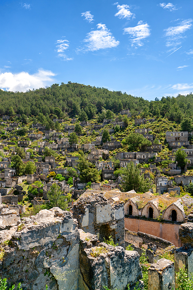 Kayakoy greek ghost town church and abandoned houses in the mountains full of vegetations in Fethiye, Turkey