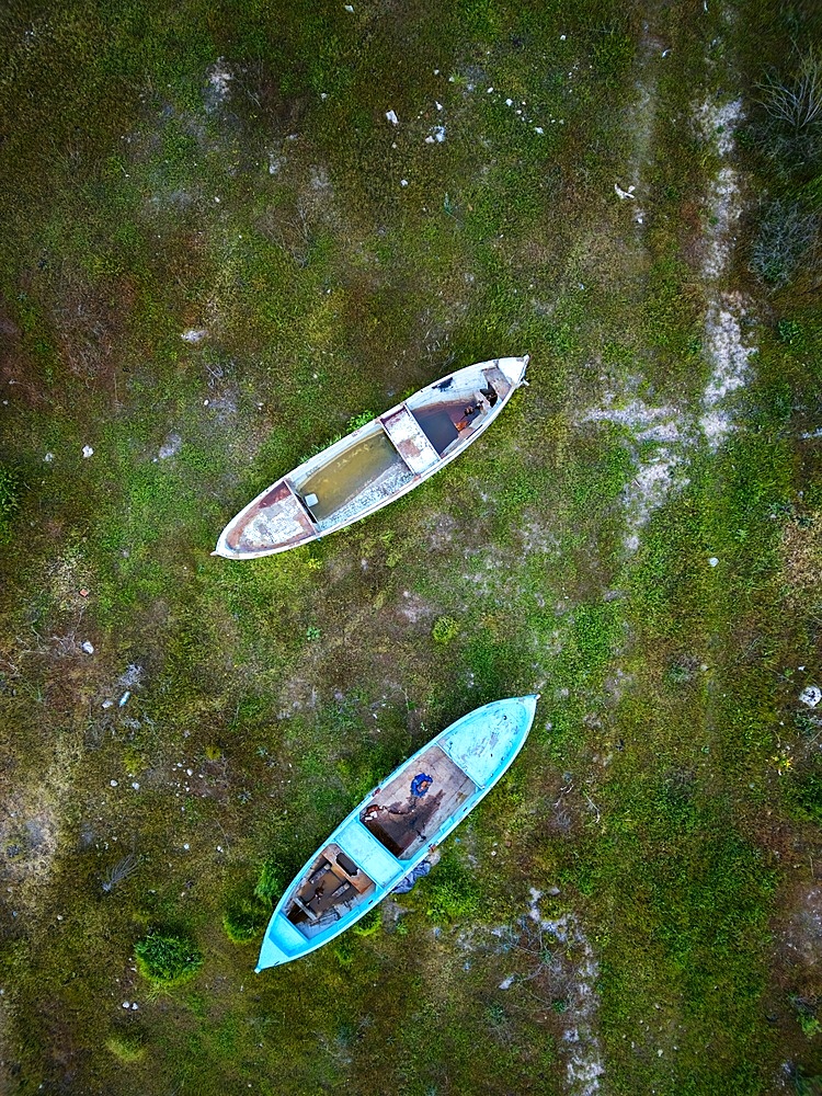Drone aerial view of abandoned boats in Marmara dry lake now full of vegetation in Turkey at sunset