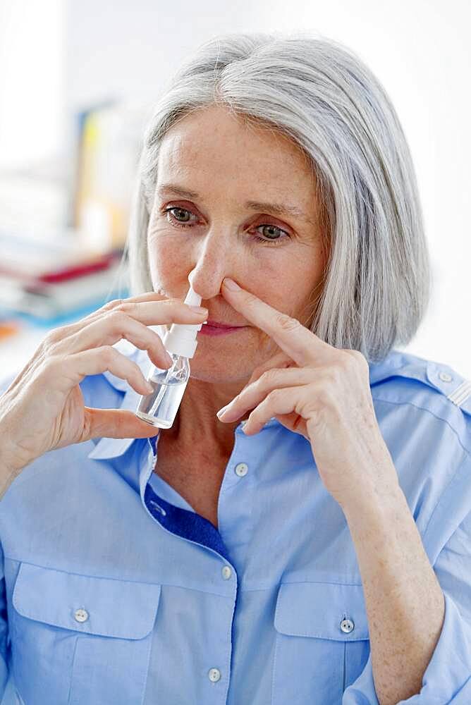 Elderly person using nose spray