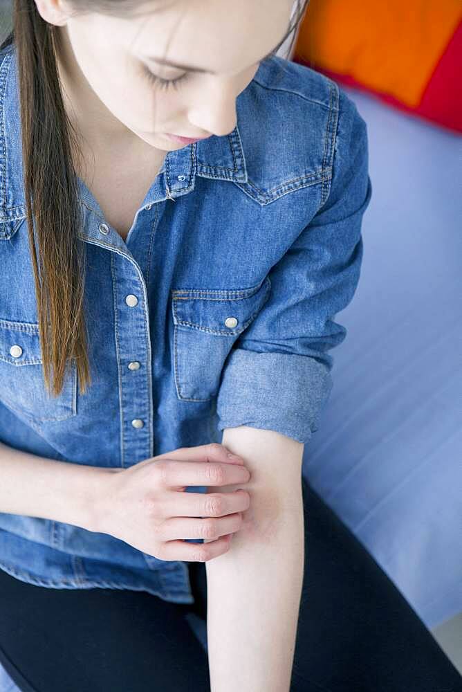 Woman scratching her arm.