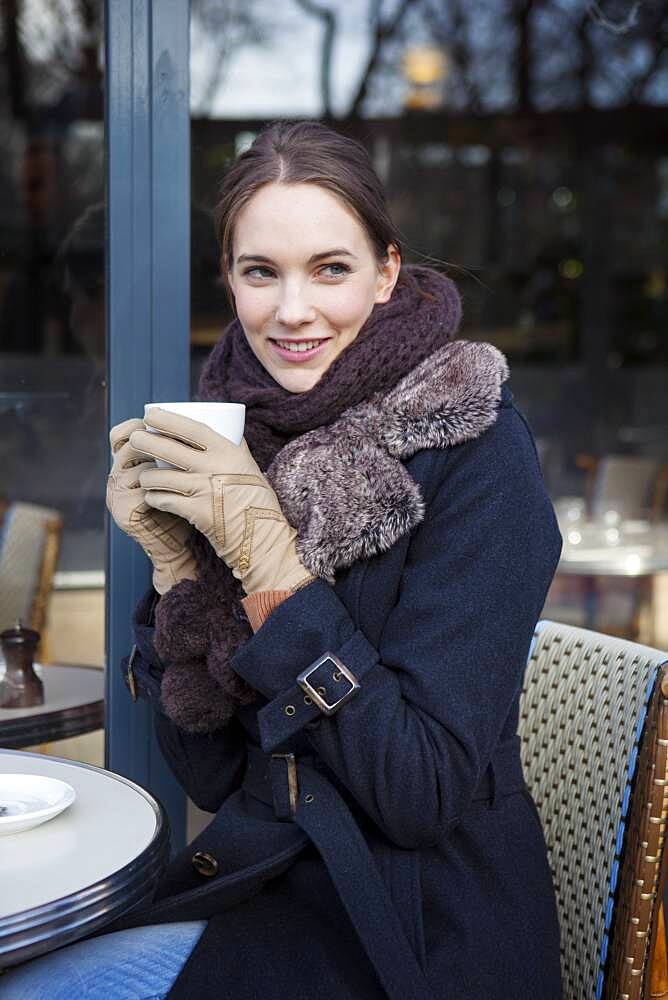 Woman drinking coffe at a terrace.