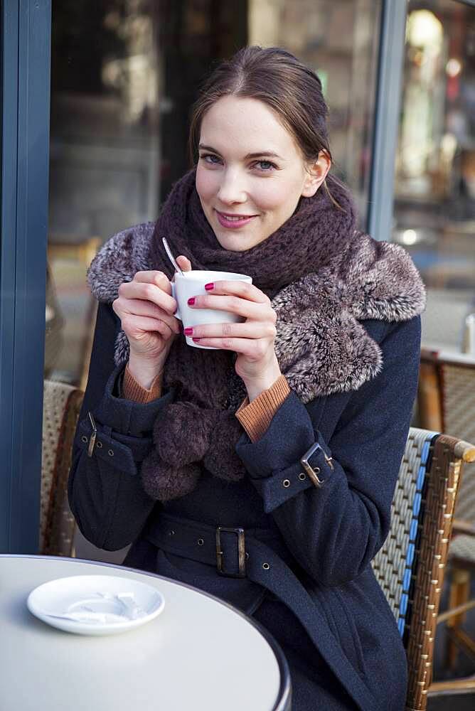 Woman drinking coffe at a terrace.