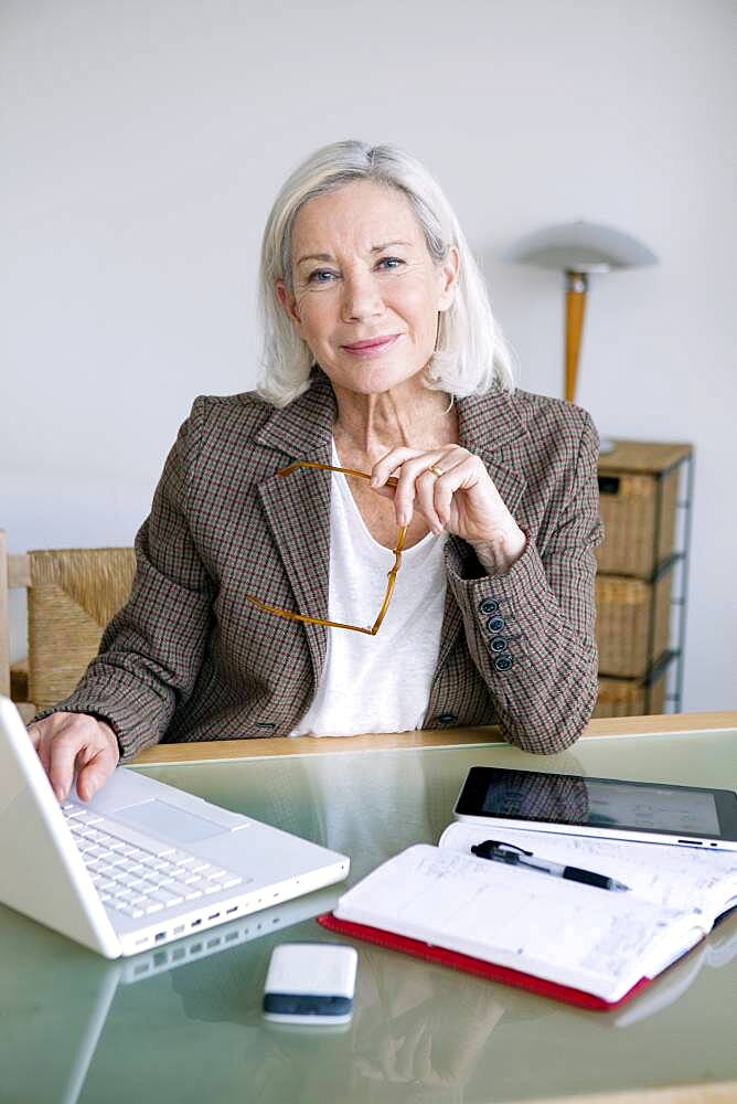 Senior woman working at home.