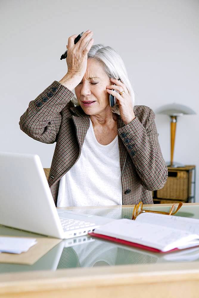 Senior woman working at home.