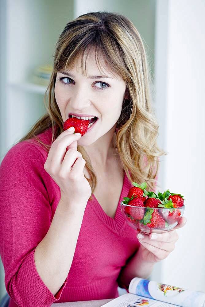 Woman eating strawberries.