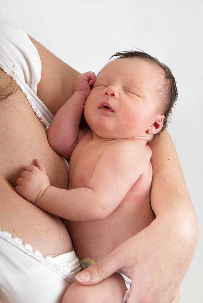 Asleep baby in mother's arms.